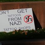 a poster reading "Don't get tattoos from Nazi Tattoo shops"